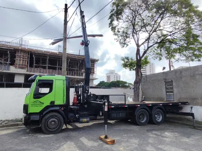 Caminhão munck com lança erguida trabalhando em obra urbana